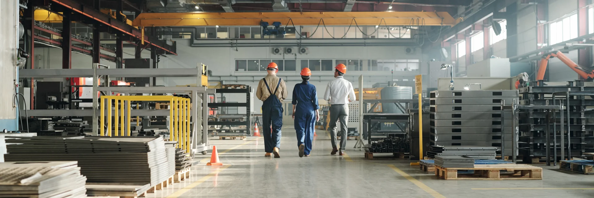 Ambiente industrial com equipamentos e profissionais trabalhando com aço